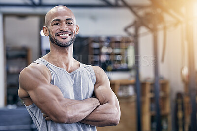Buy stock photo Portrait of a muscular young man standing with his arms crossed in a gym