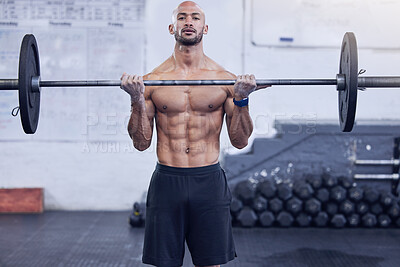 Buy stock photo Shot of a young man working out with a barbell at the gym