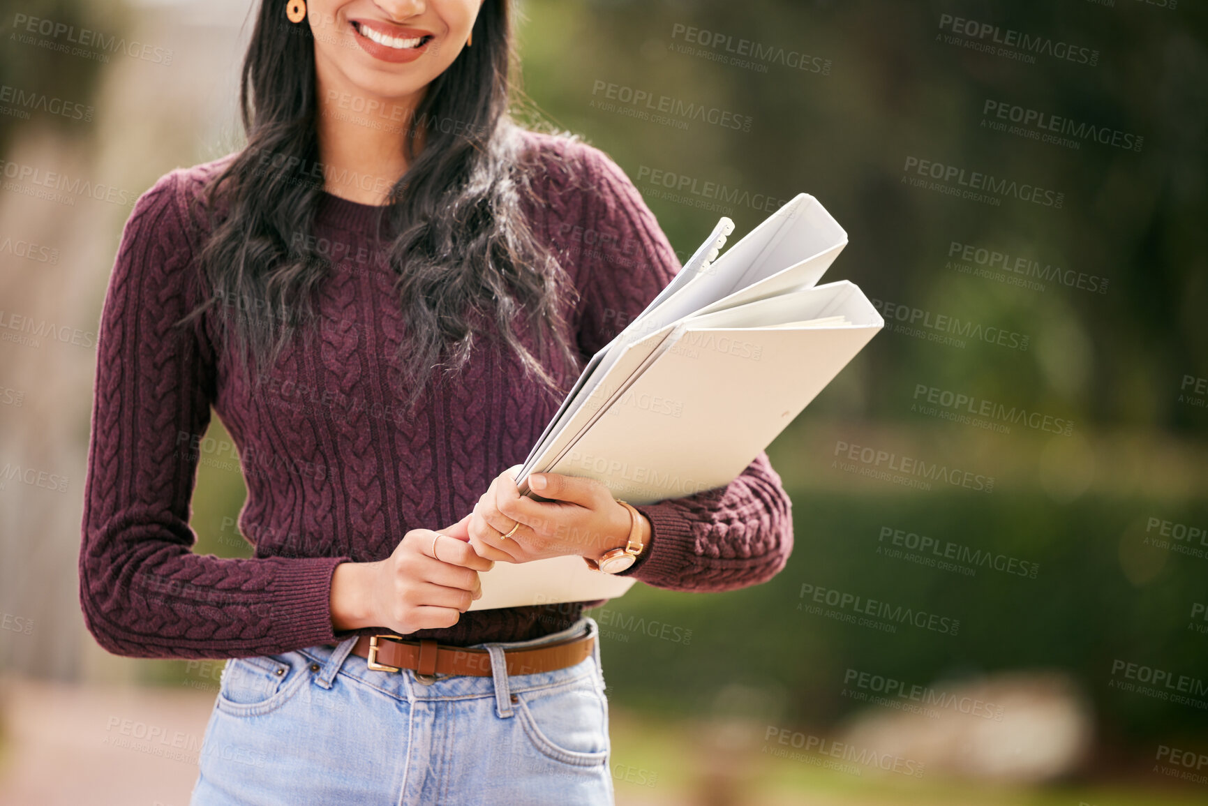 Buy stock photo Shot of a young woman carrying her schoolbooks outside at college