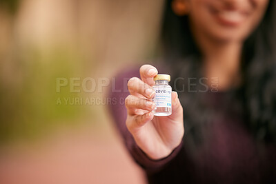 Buy stock photo Shot of an unrecognisable woman holding a vial filled with the Covid-19 vaccine outside at college