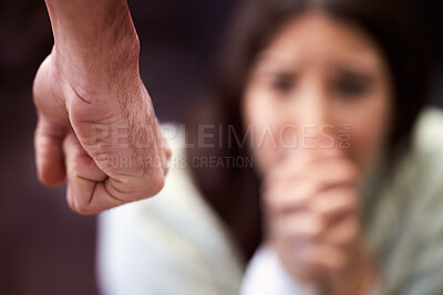 Buy stock photo Shot of a man’s fist with a woman looking scared in the background