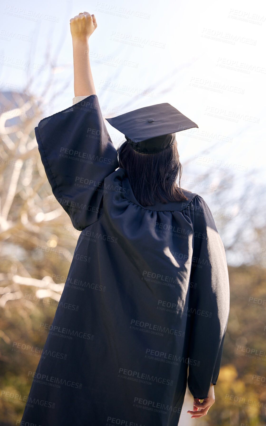 Buy stock photo Rearview shot of a young woman cheering on graduation day