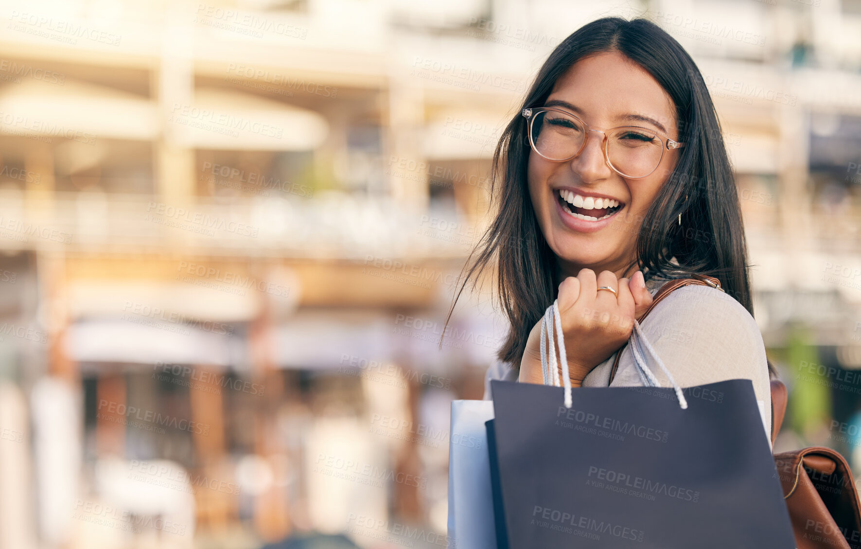 Buy stock photo Portrait of an attractive young woman walking alone outside while shopping in the city