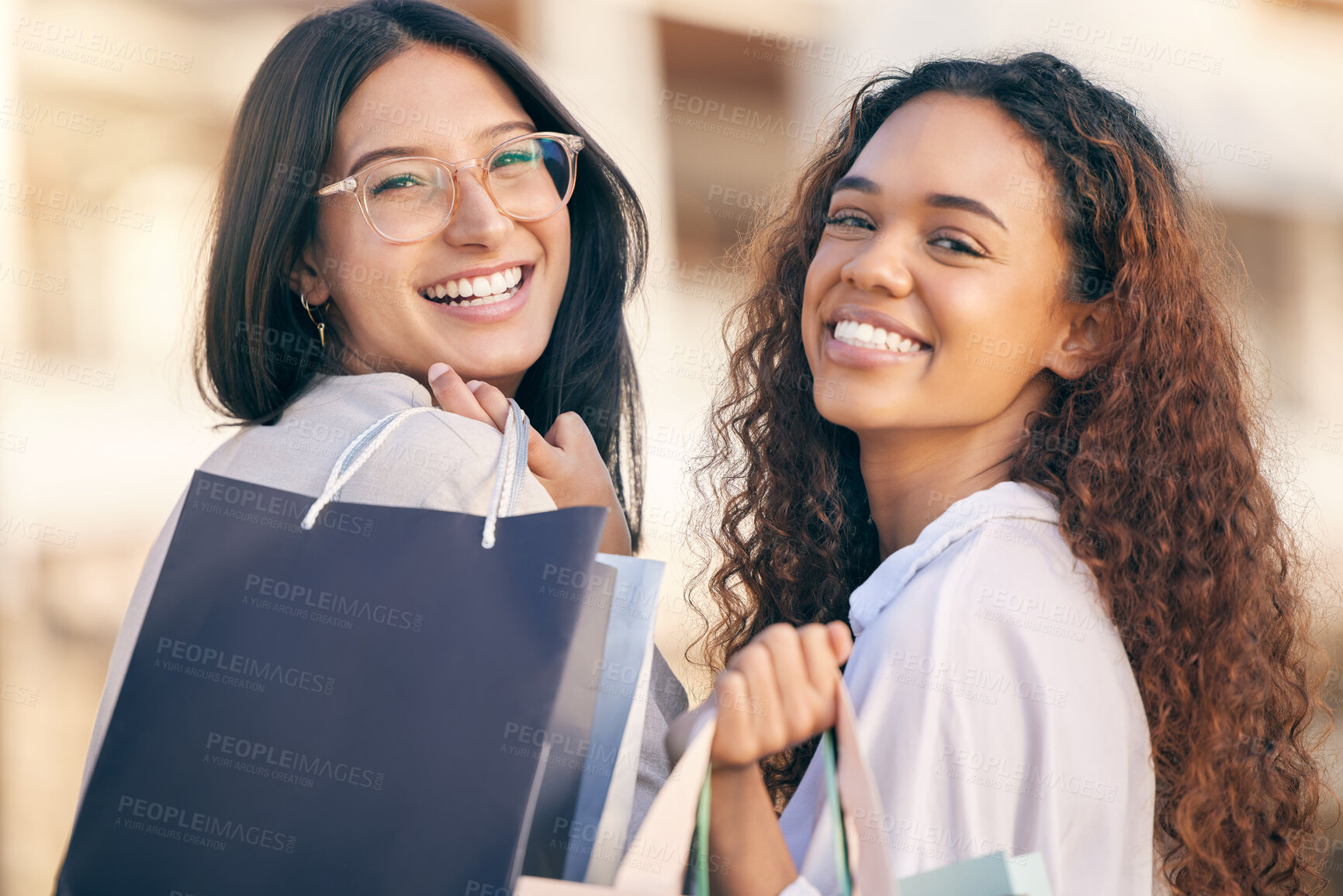 Buy stock photo Portrait of two attractive young women standing outside together and bonding while shopping in the city