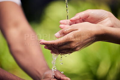 Buy stock photo Shot of unrecognisable people ringing their hands with water outside