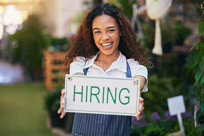 Buy stock photo Shot of a young business owner holding a sign stating that she's hiring
