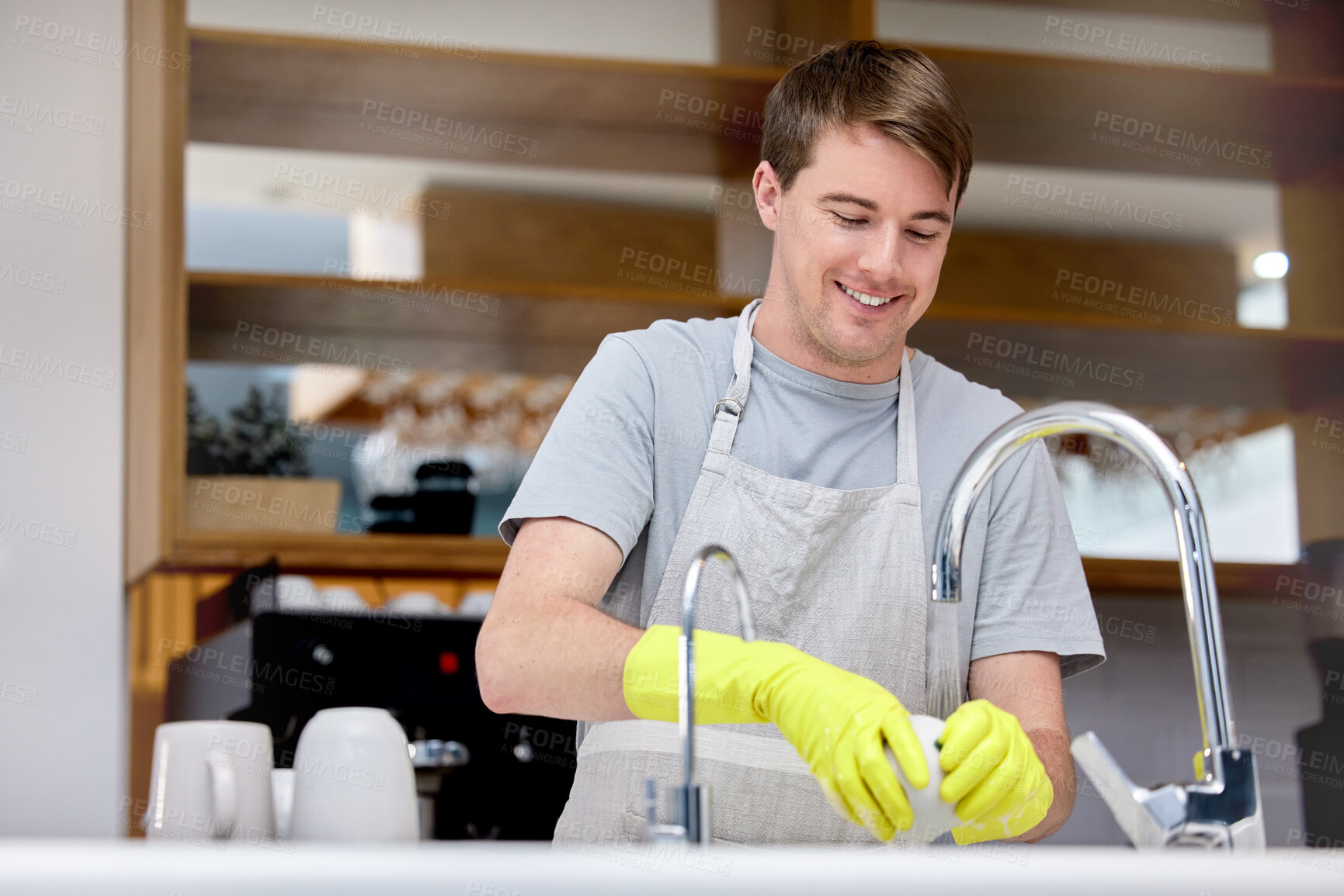 Buy stock photo Cleaning, washing and dishes for man in home kitchen, chores and gloves for hand. Dirty, smile or hygiene with soap for bacteria prevention, germs and messy for disinfect crockery for male person