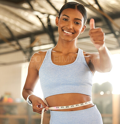 Buy stock photo Measure, lose weight or happy woman with thumb up or tape for waist or body goals in fitness studio. Gym, thumbs up or healthy girl measuring her stomach for goal progress, training or motivation 