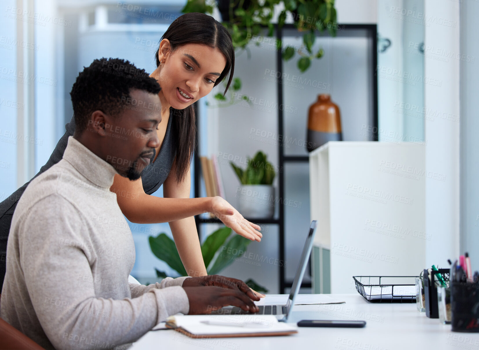 Buy stock photo Shot of two businesspeople working together on a laptop in an office