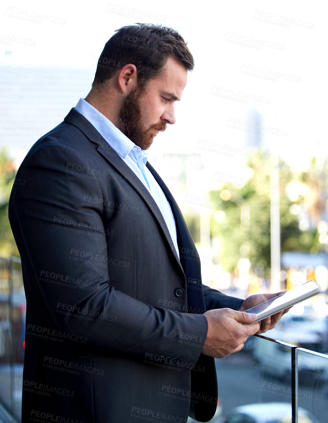 Buy stock photo Shot of a young businessman using a digital tablet on his office balcony