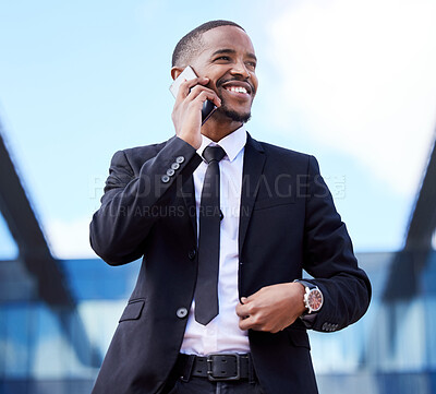 Buy stock photo Shot of a young businessman using a phone in the city