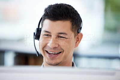 Buy stock photo Shot of a young call centre agent working on a computer in an office