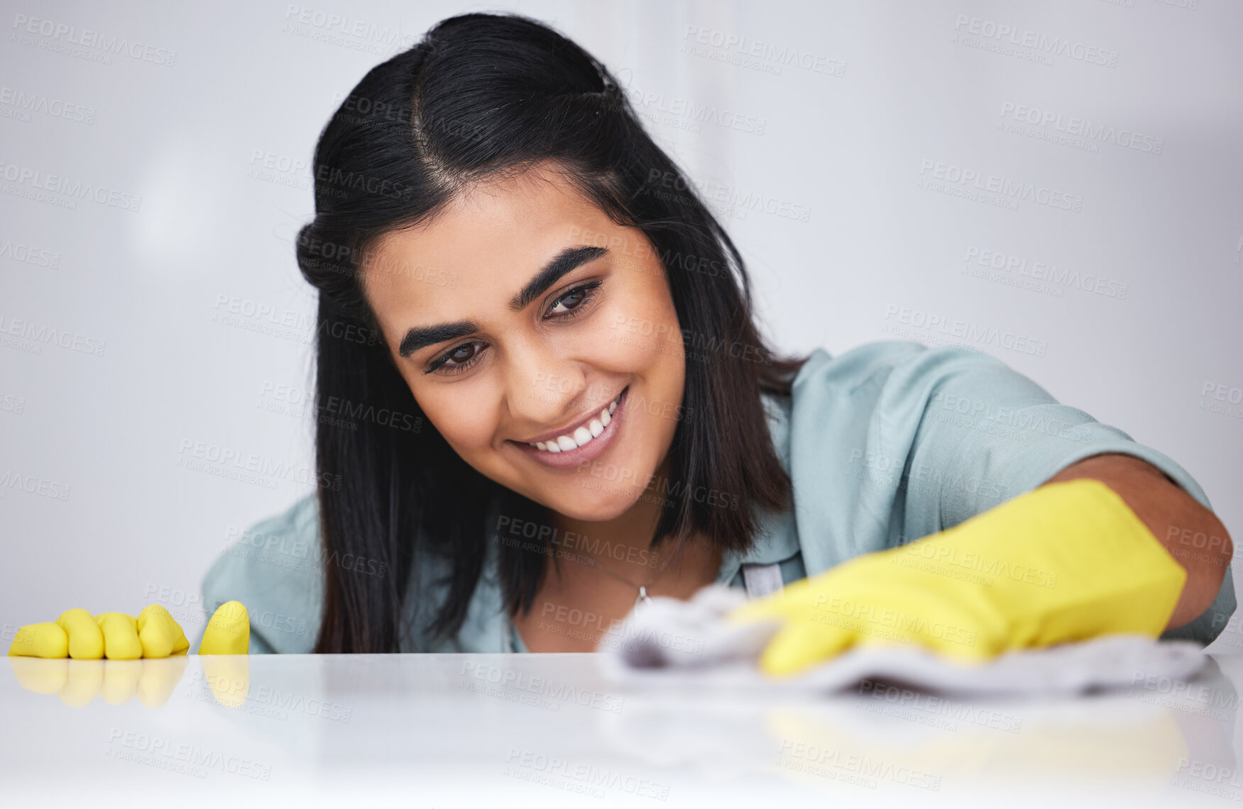 Buy stock photo Indian woman, happy or cleaner with spray bottle for table, kitchen counter or dirty furniture in home. Smile, maid or janitor washing messy surface with product, liquid soap or cloth with gloves 