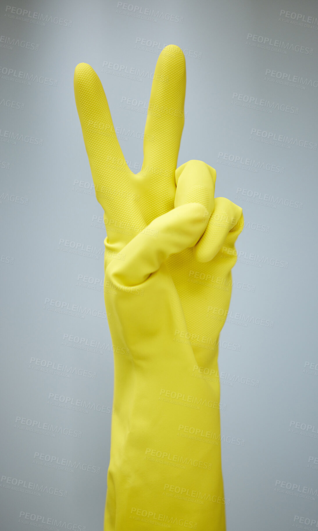 Buy stock photo Shot of a hand showing the peace sign while wearing yellow rubber gloves