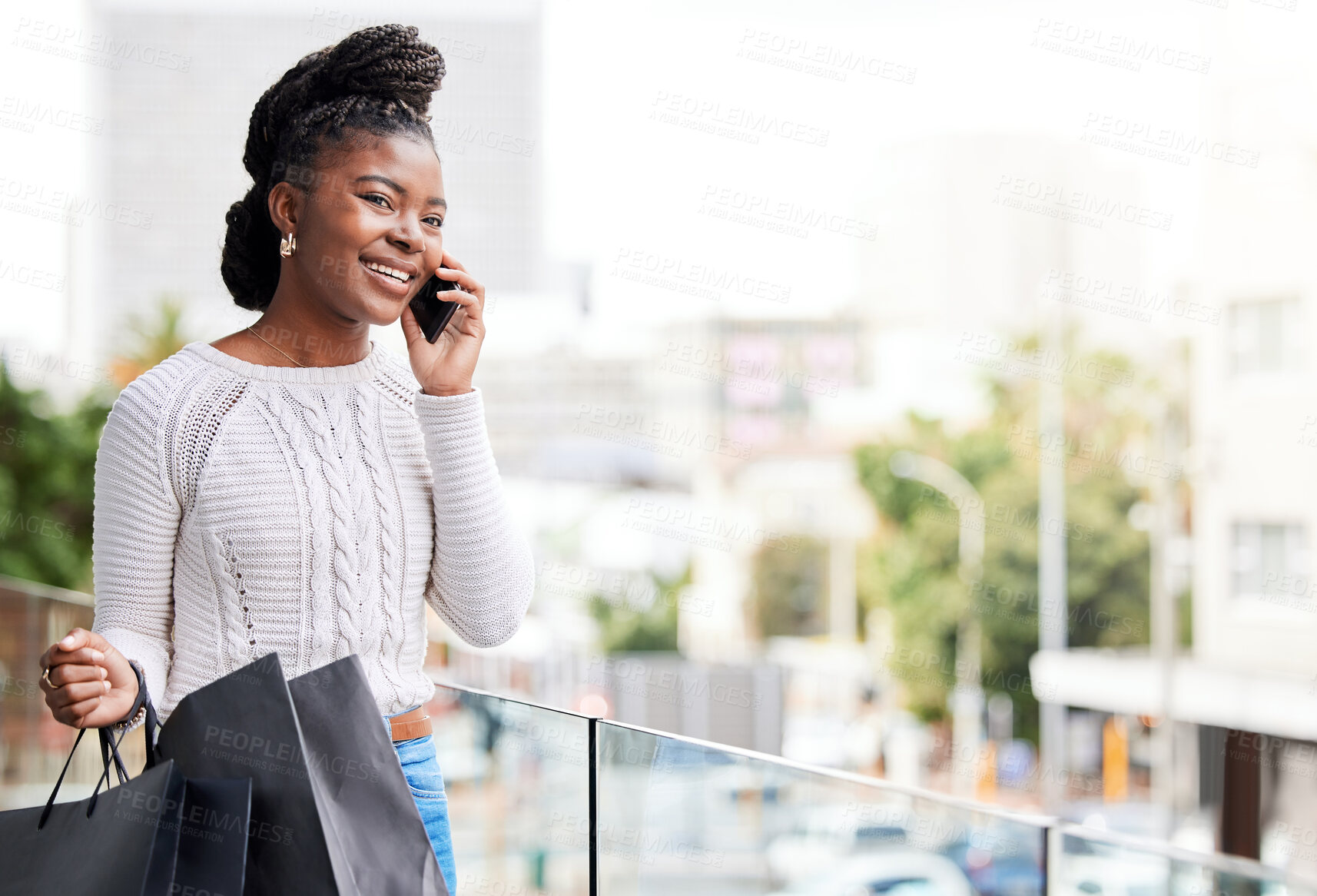 Buy stock photo Shot of a young woman taking a break from shopping to make a phone call