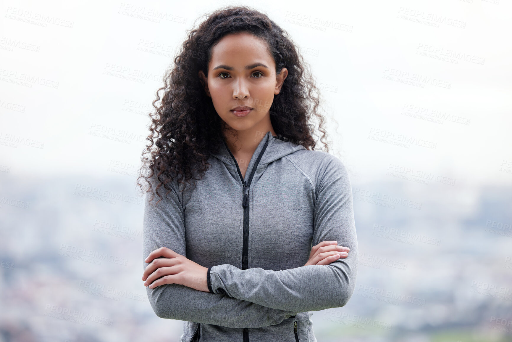 Buy stock photo Shot of a beautiful young woman standing with her arms crossed while out for a run