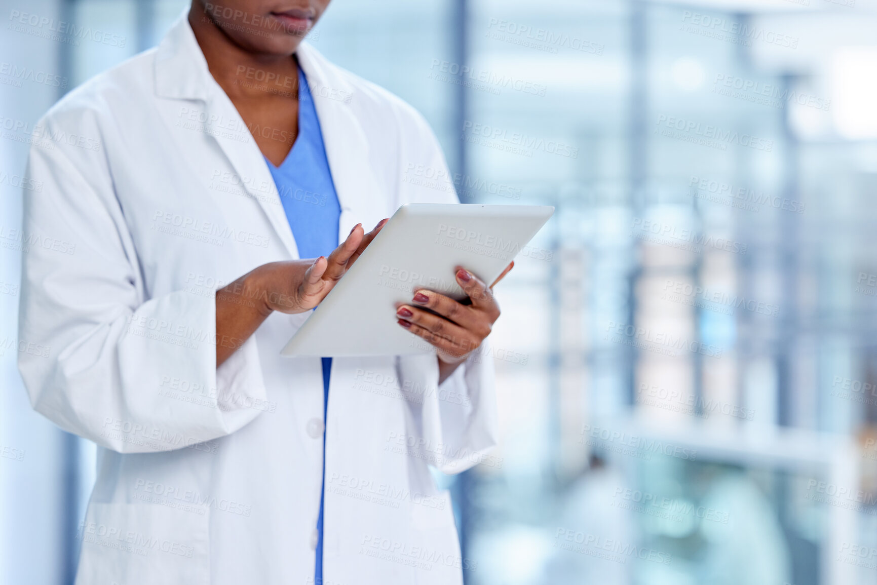 Buy stock photo Shot of an unrecognizable doctor using a digital tablet at work