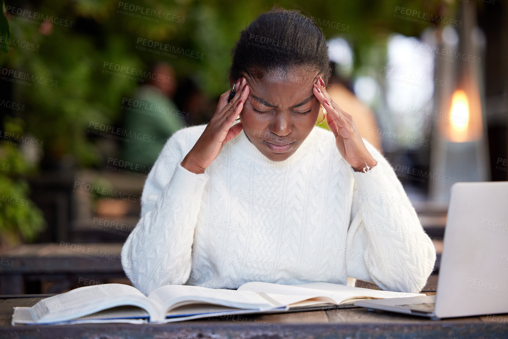 Buy stock photo Shot of a young woman looking stressed while studying in a cafe