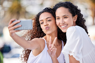 Buy stock photo Shot of two young women taking selfies during a fun day outdoors