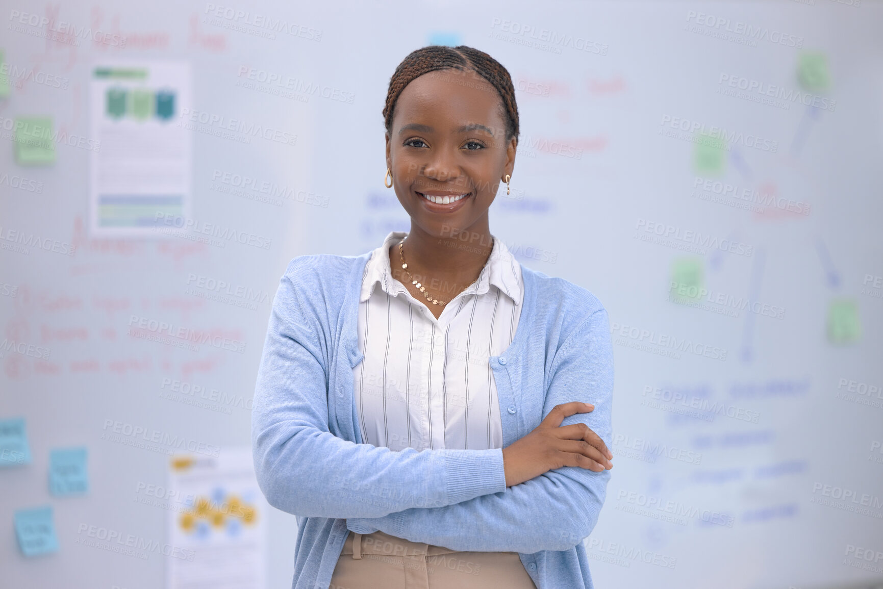 Buy stock photo Portrait of a confident young businesswoman standing with her arms crossed in front of a whiteboard in an office