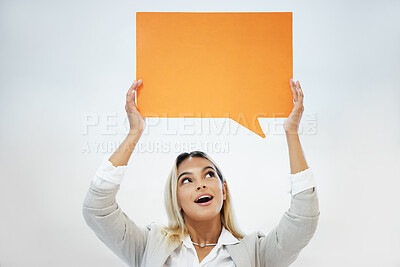 Buy stock photo Shot of a young woman holding a speech bubble against a studio background