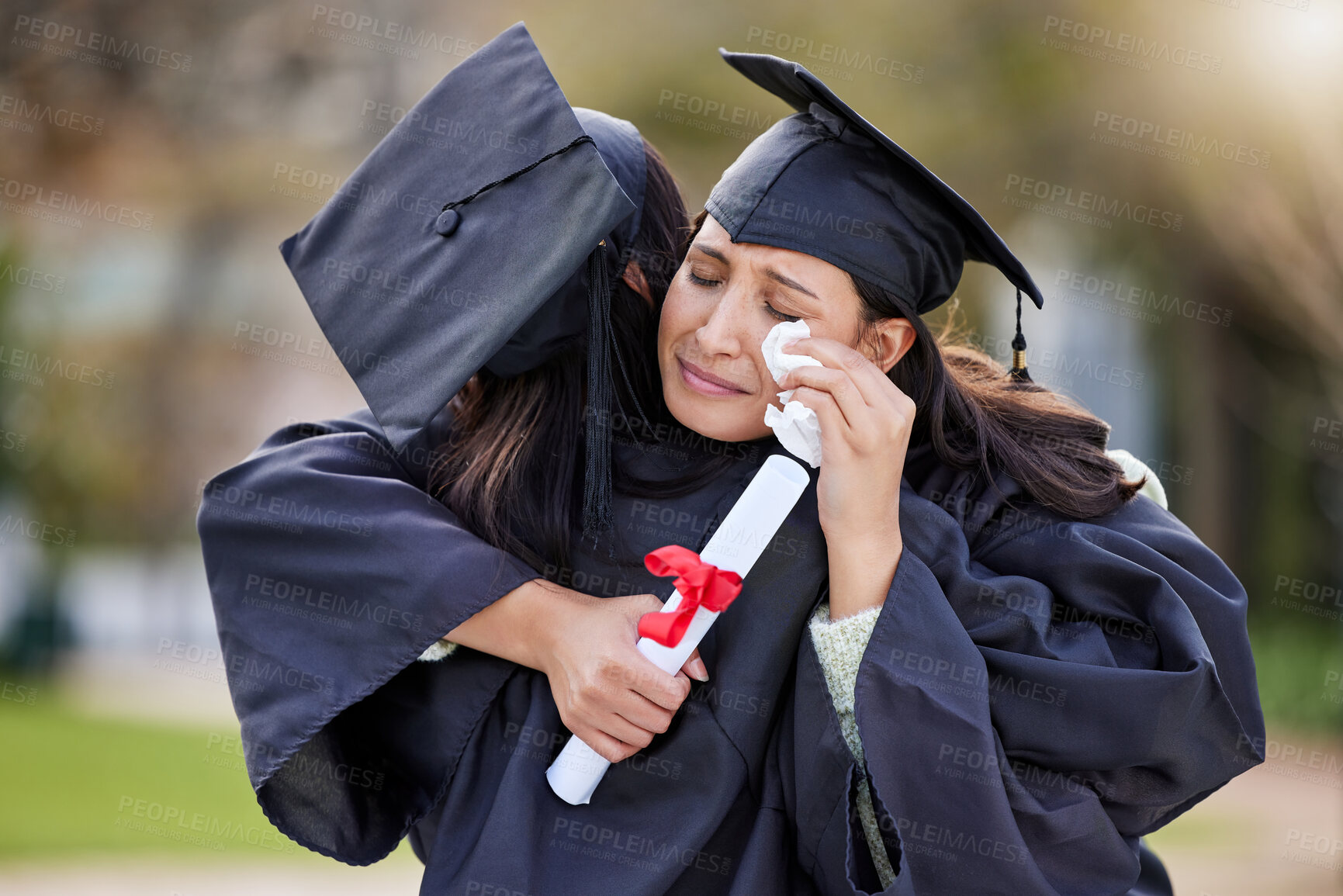 Buy stock photo Cropped shot of an attractive young female student crying while hugging her friend on graduation day