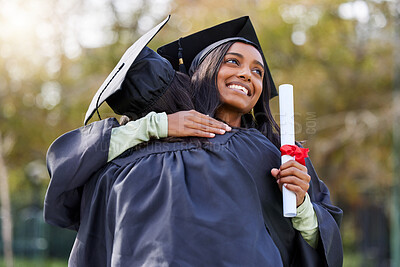 Buy stock photo Cropped shot of an attractive young female student hugging her friend while celebrating on graduation day