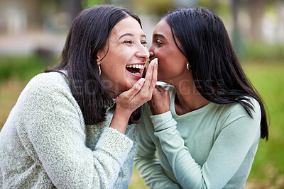 Buy stock photo Shot of two young women telling secrets outside at college