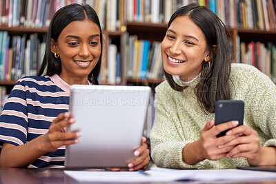 Buy stock photo Shot of two females using their  devices in a library