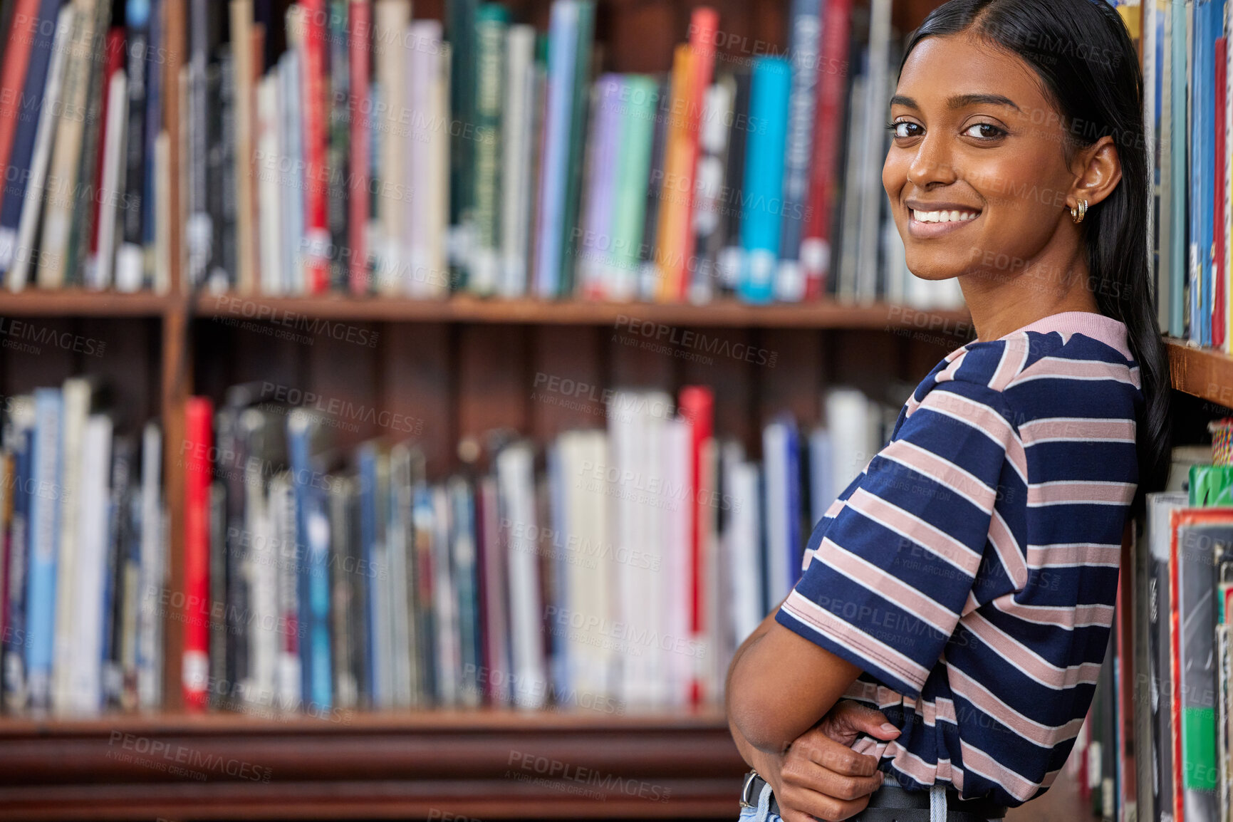 Buy stock photo Shot of a female standing in a library