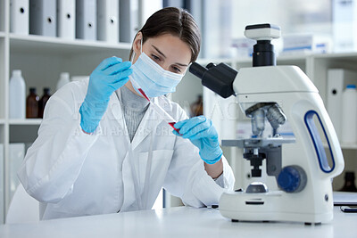 Buy stock photo Shot of a young woman using a dropper and test tube while working with samples in a lab