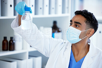Buy stock photo Shot of a young man analysing a sample in a lab
