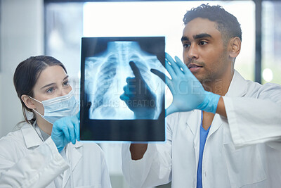 Buy stock photo Shot of two doctors analysing an x-ray together in a hospital