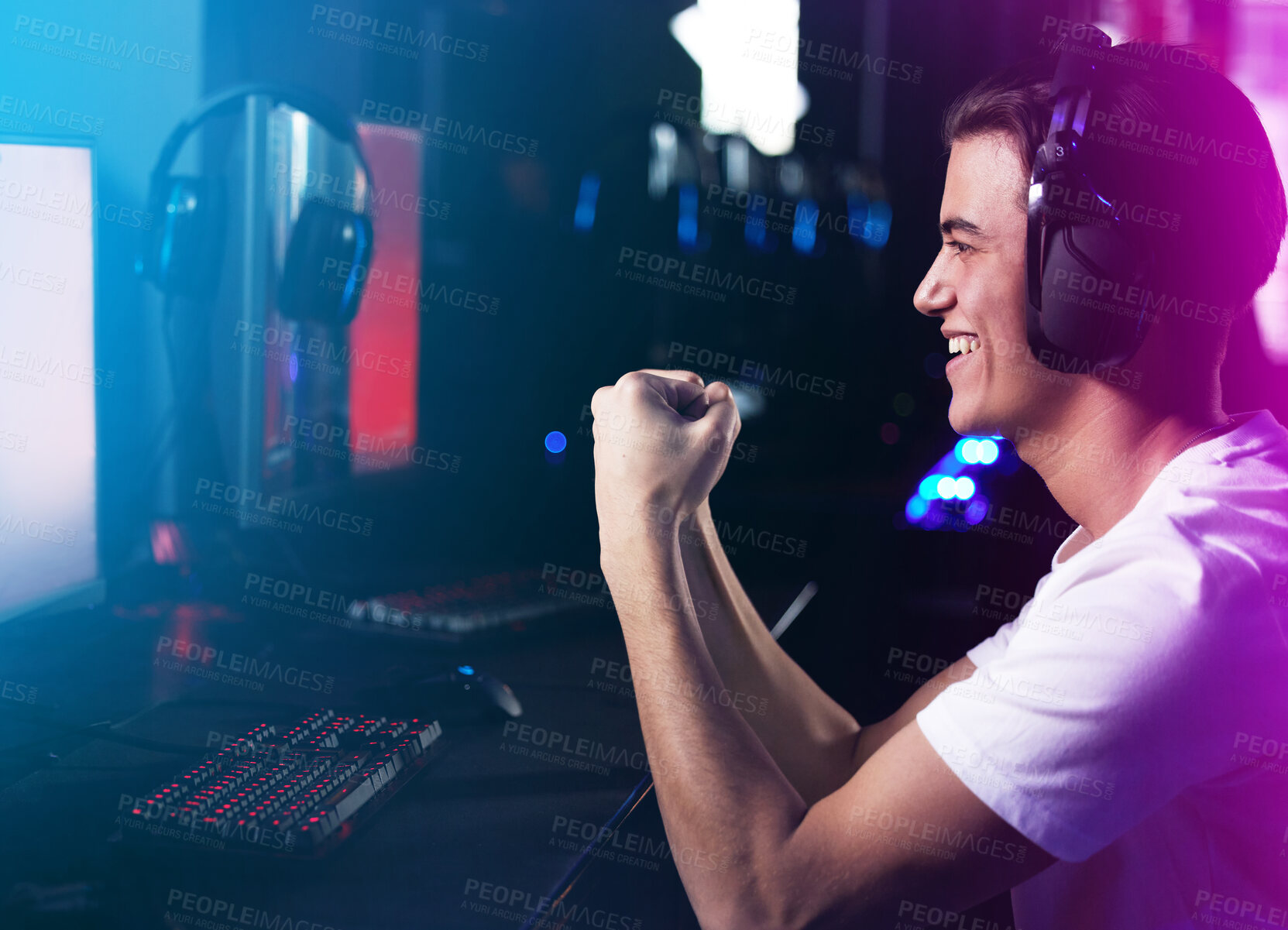 Buy stock photo Shot of a young man cheering while playing computer games