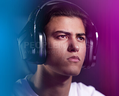 Buy stock photo Neon, face and man as pro gamer with playing on computer for online video games and serious. Headphones, esports and hobby at home with intense contest or challenge and competition with confidence 