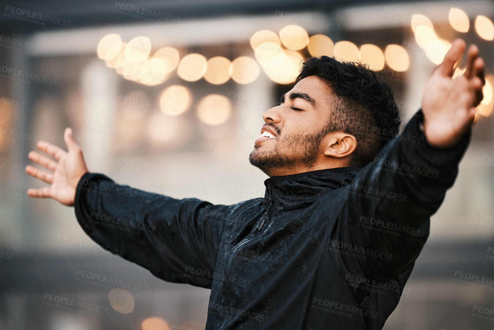 Buy stock photo Outdoor, happiness and freedom of man for rain, spring weather and calming atmosphere. Bokeh, male person and hand gesture for celebration, nostalgia and carefree attitude while wet in nature