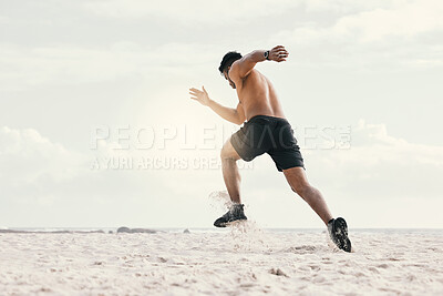Buy stock photo Shot of a young man out for a run on the beach