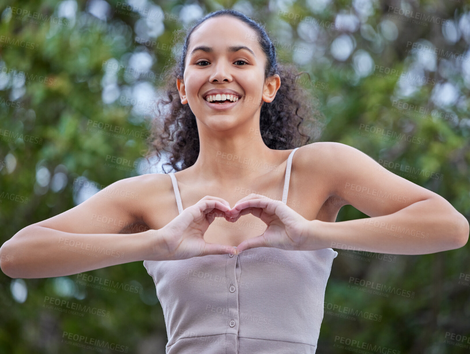 Buy stock photo Girl, portrait and confident in nature for heart hands, trees and smile in park for weekend trip. Female person, emoji and proud of peace or kindness in garden, vacation and love by plants in outdoor