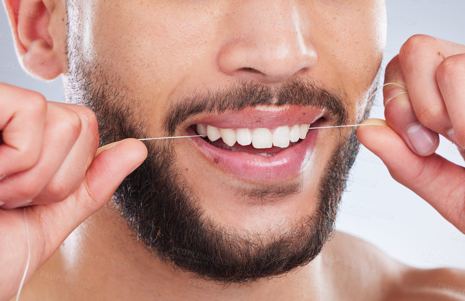 Buy stock photo Studio shot of an unrecognisable man flossing his teeth against a grey background