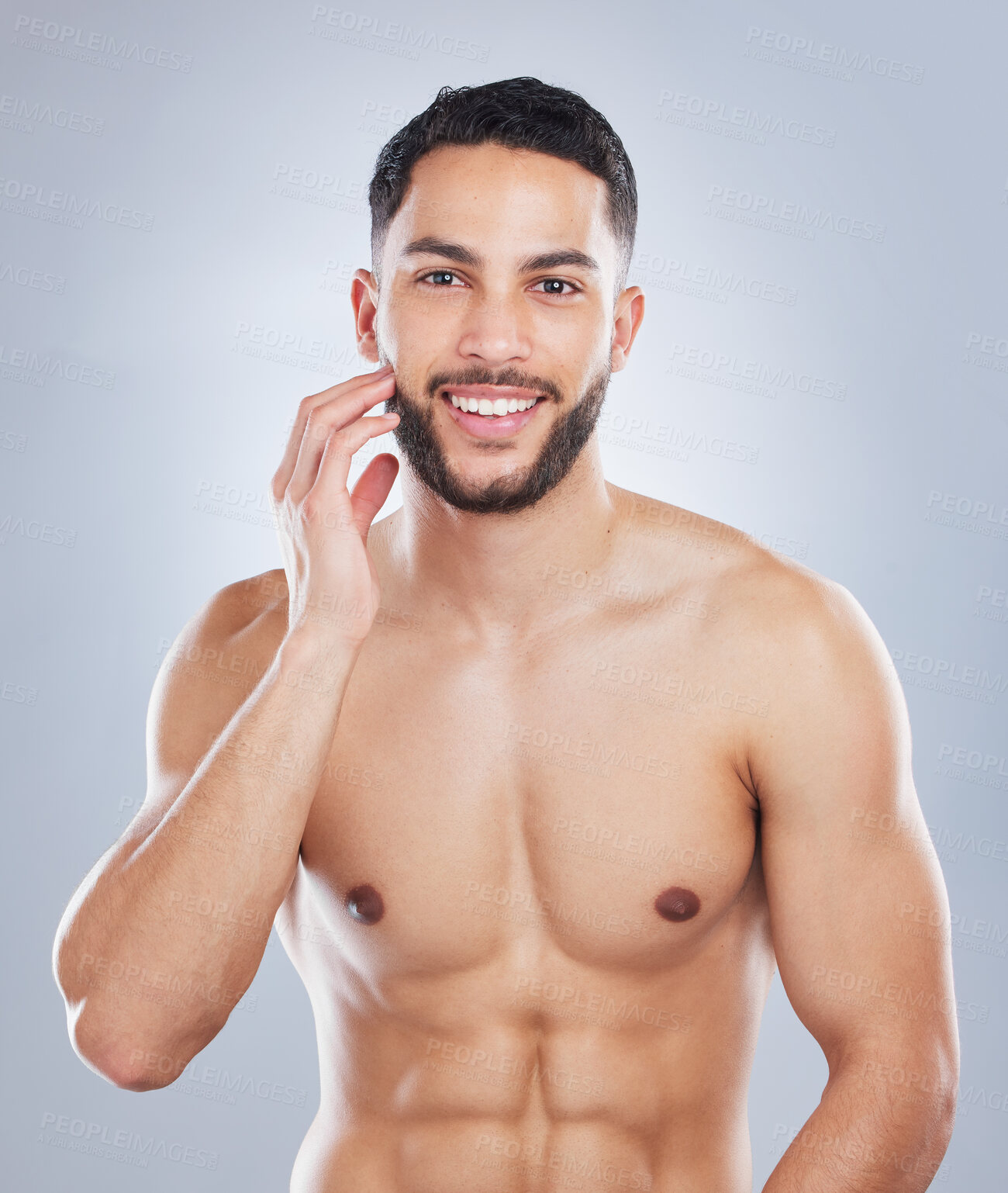 Buy stock photo Studio shot of a handsome young man touching his face against a grey background