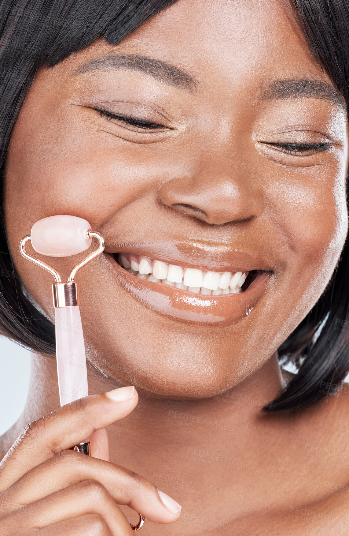 Buy stock photo Black woman, rose quartz roller and studio with smile for skin routine with natural glow by background. Girl, person and happy with stone, crystal or product for beauty, health and cosmetic change