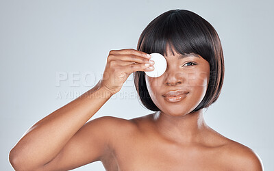 Buy stock photo Studio shot of an attractive young woman wiping her face with cotton against a grey background