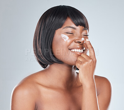 Buy stock photo Happy, black woman and skincare with cream for facial treatment or moisturizer on a white studio background. African, female person or young model with smile for lotion, cosmetics or healthy skin