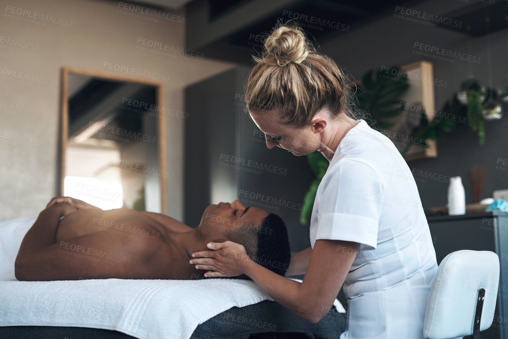 Buy stock photo Shot of a young man getting a face massage at a spa