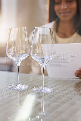 Buy stock photo Shot of an unrecognisable woman sitting alone and looking at the menu during a wine tasting