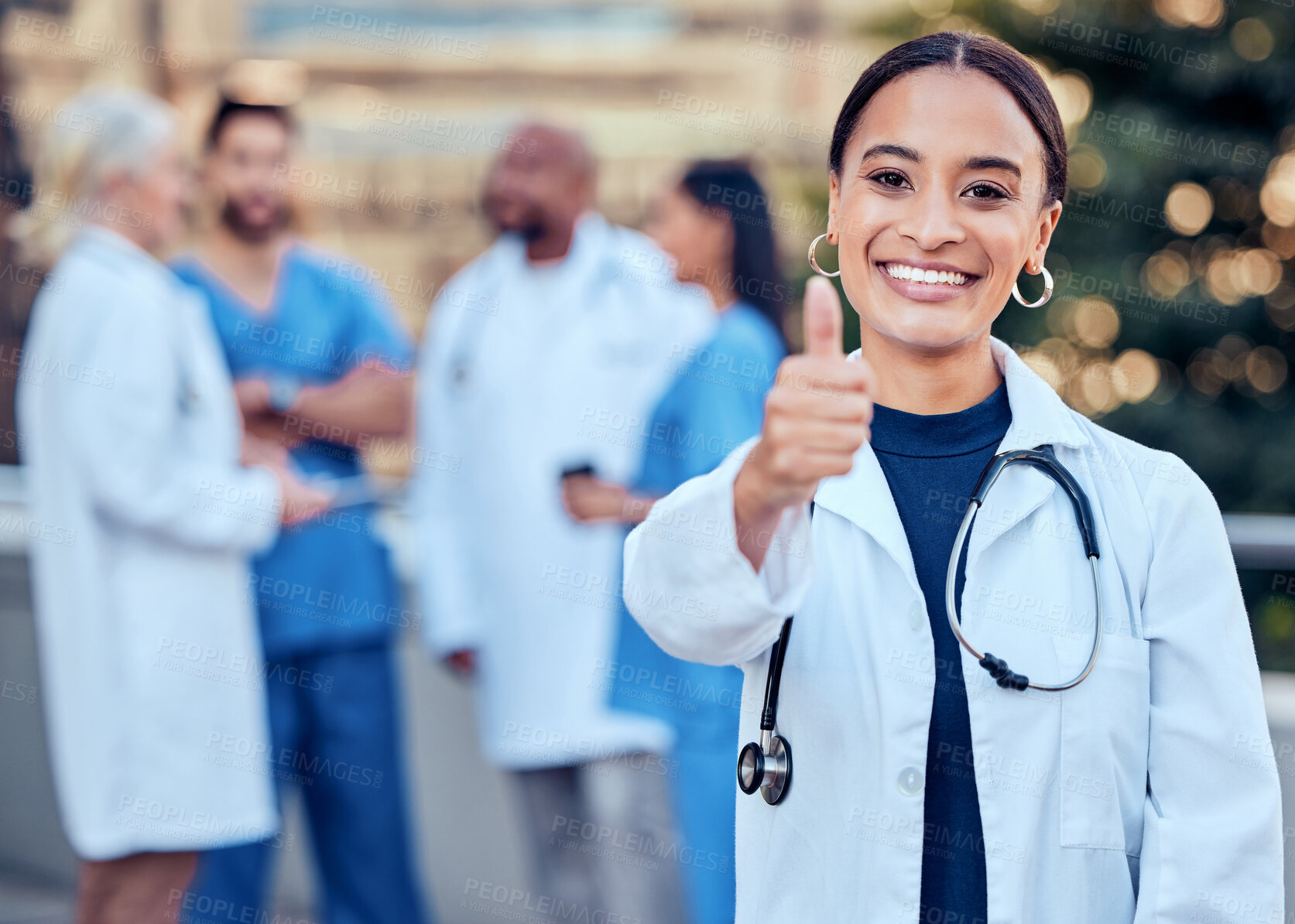 Buy stock photo Success, thumbs up and portrait of a woman doctor with her team outdoor at the hospital. Leadership, smile and healthcare worker with an approval hand gesture with colleagues outside a medical clinic
