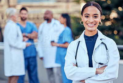 Buy stock photo Confidence, crossed arms and portrait of a female doctor with her team outdoor at the hospital. Leadership, smile and healthcare worker standing with a group of colleagues outside a medical clinic.