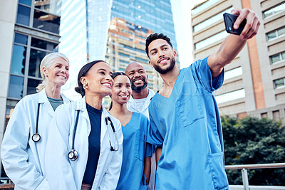 Buy stock photo Group, doctors and phone with selfie in city for profile picture, together with smile for social media. Medical, team or photo with diversity in urban with internet, working in healthcare or hospital