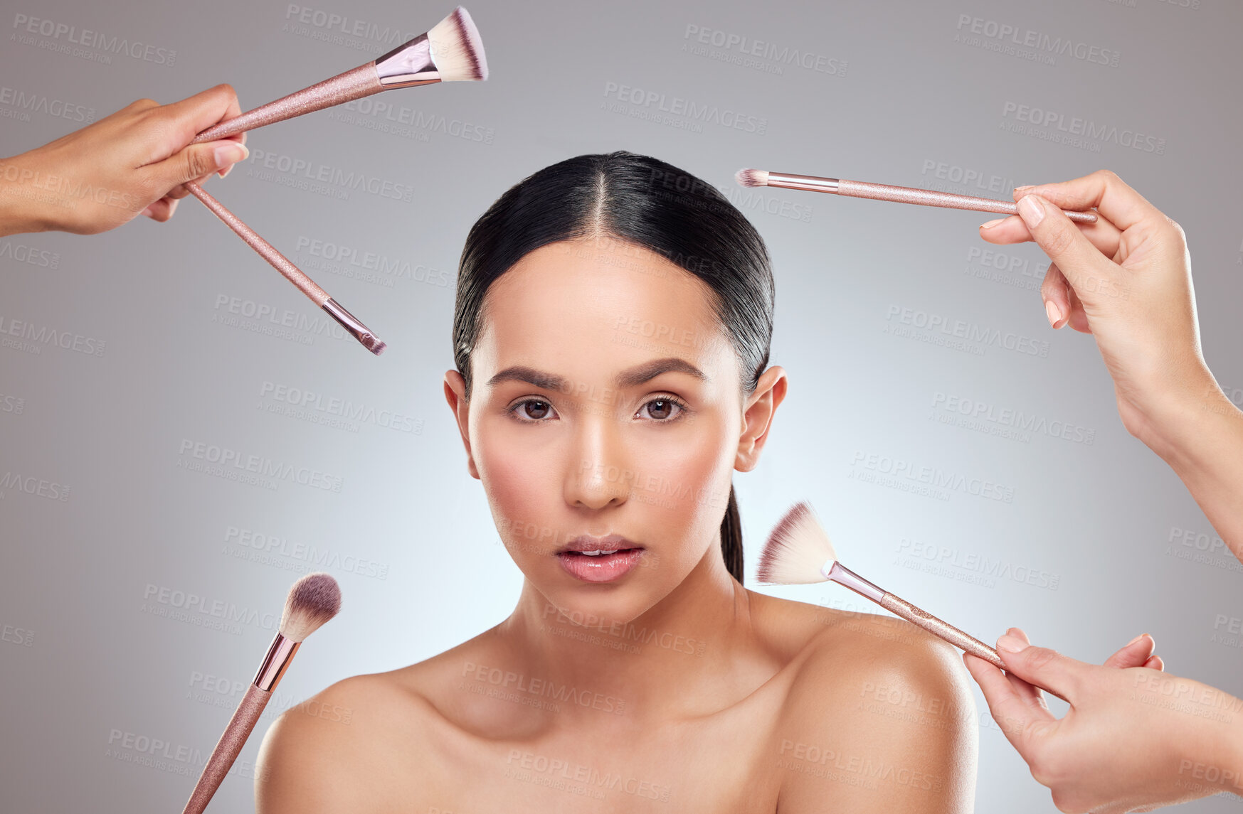 Buy stock photo Studio portrait of a beautiful young woman having makeup applied to her face against a grey background