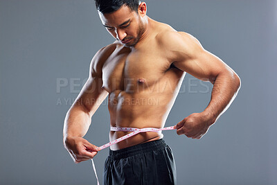 Buy stock photo Model, body and measurement for waist, weight loss and management for fat control or bmi and diet wellness. Fitness man, sports athlete or guy with tape measure for muscle goals on studio background